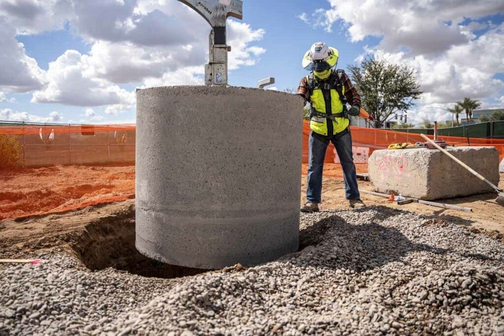 Dry well construction team member installing pipe setting WW Clyde