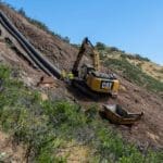 Placing concrete as an anchor for pipe retention in mountain side